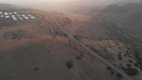 Vista-Aérea-Alrededor-De-Una-Carretera-En-Las-Tierras-Altas-De-Los-Altos-Del-Golán,-Puesta-De-Sol-En-Israel---Dando-Vueltas,-Disparo-De-Drones