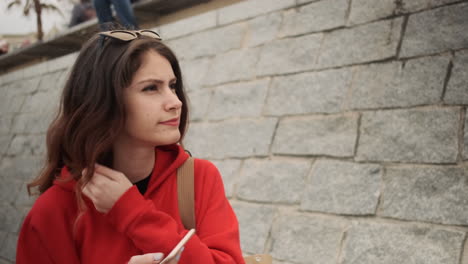 young girl with smartphone waiting in the street