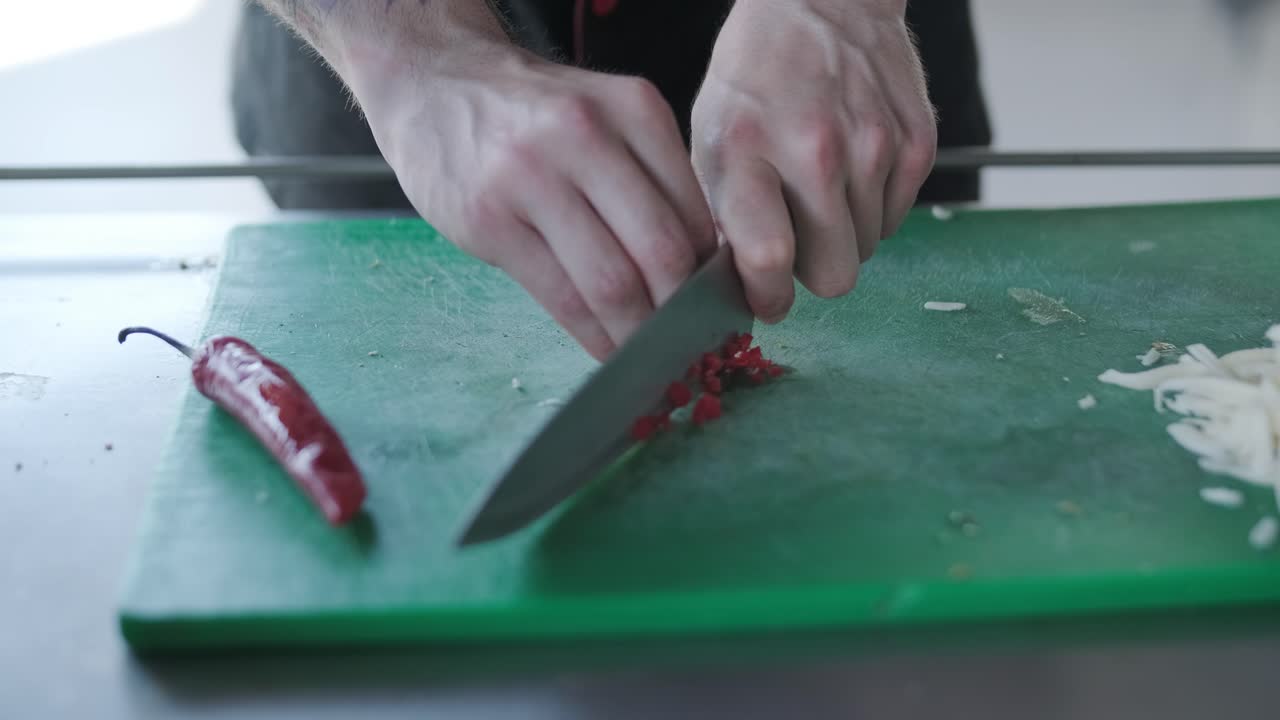 el chef cortando pimientos rojos