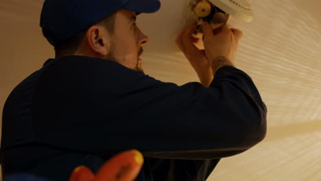hombre arreglando el detector de fuego