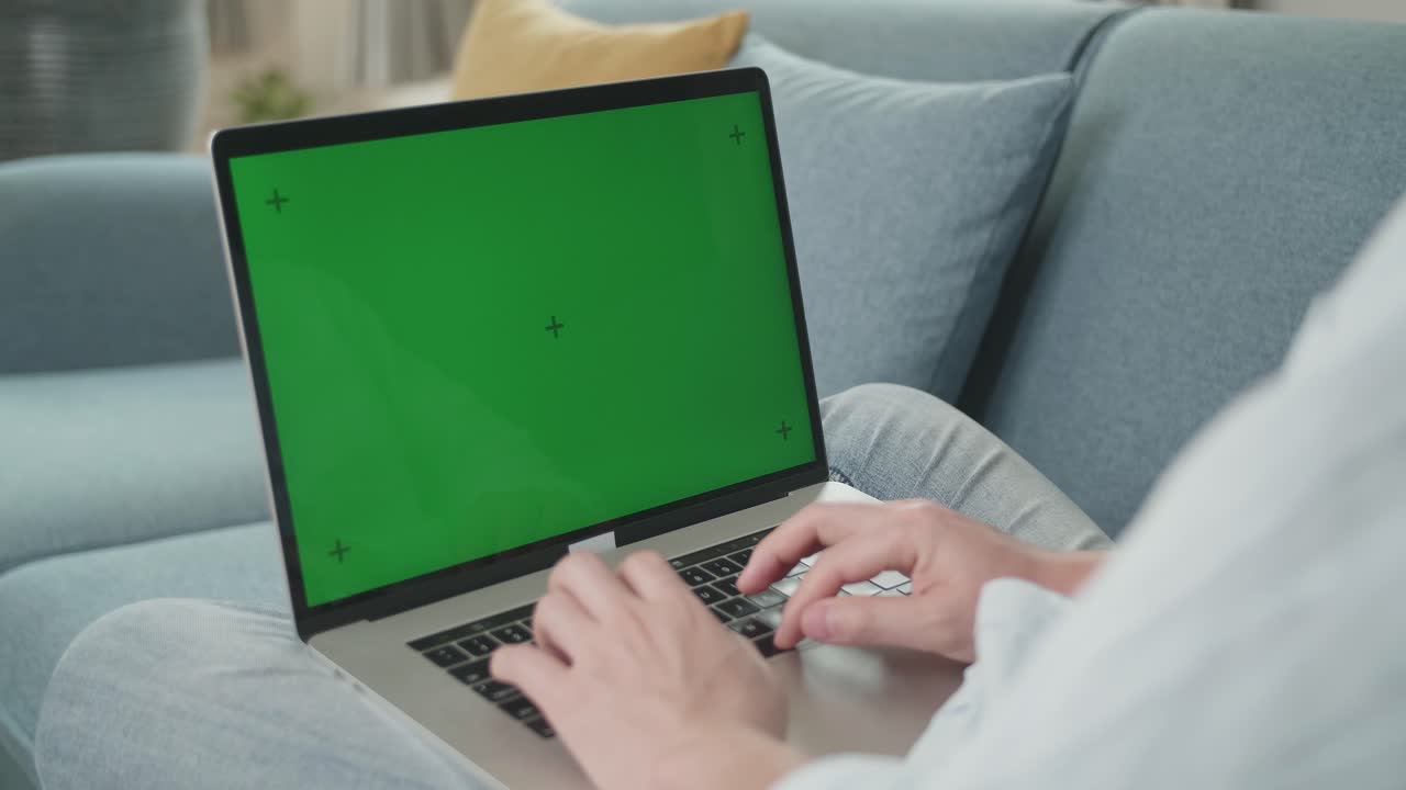 Man Hands Typing On Laptop With Green Screen Mock Up Display On Sofa, Video In 4K