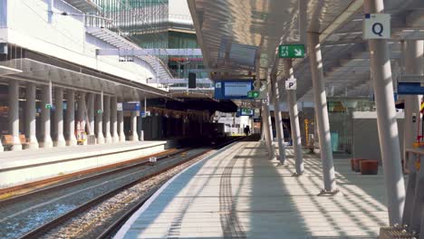 Mann-Zu-Fuß-Auf-Dem-Bahnsteig-Am-Amsterdamer-Hauptbahnhof-In-Amsterdam,-Niederlande---Zoom-out-Aufnahme