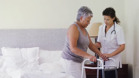 female doctor helping senior woman to walk with walker 4k