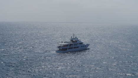 establishing shot of an expensive yacht sailing through the ocean