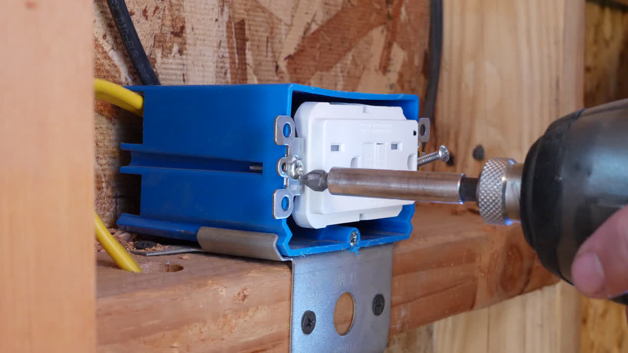 строительный рабочий-электрик использует дрель для удаления электрической розетки во время ремонта дома