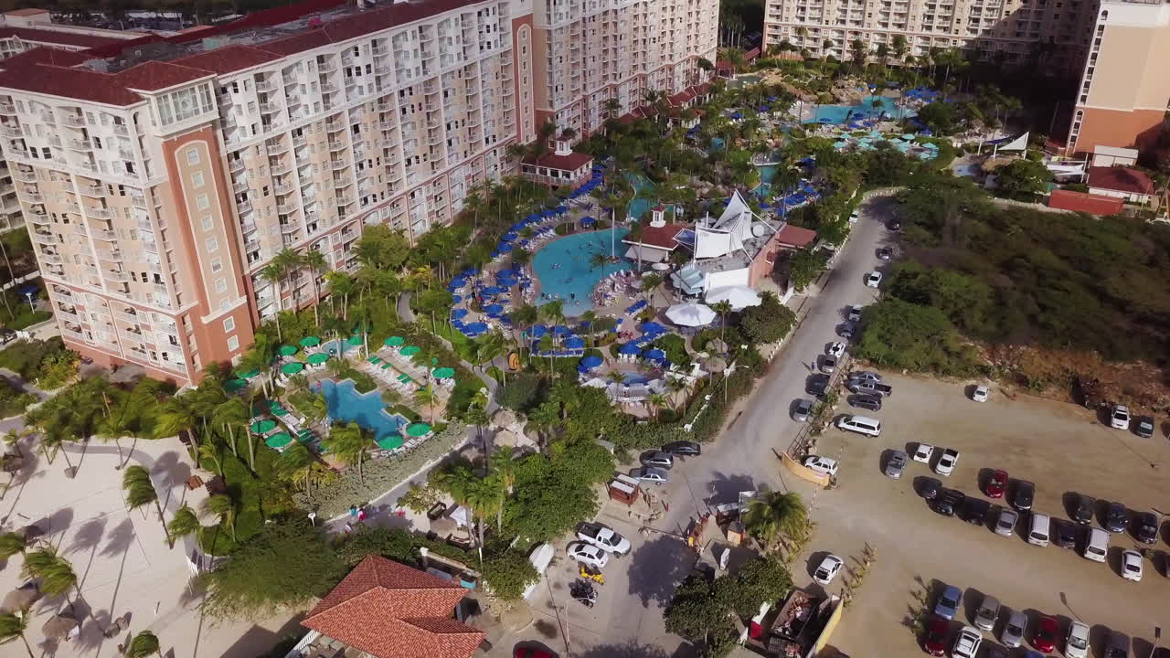 Turistas nadando en la piscina de un hotel de gran altura en un resort en Palm Beach, Aruba.