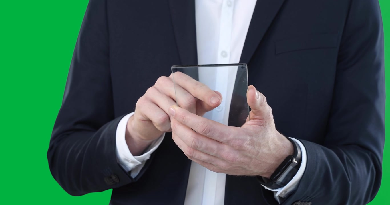 Tapping top left corner man in suit holding glass panel in studio, demoing UI with smartwatch