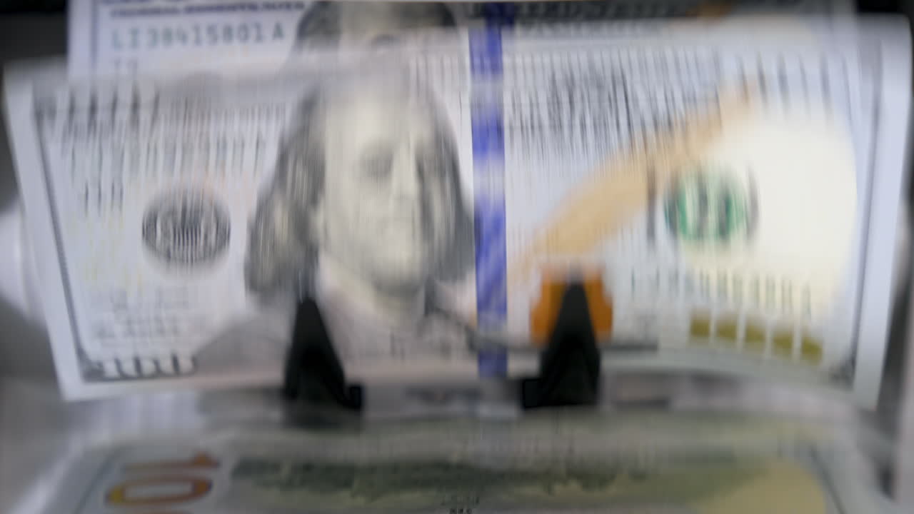 Currency counting machine. Automatic equipment for banking financial transactions. Counter machine with US money banknotes of 100 dollars. Bank automatic equipment for counting cash money. Macro shot.