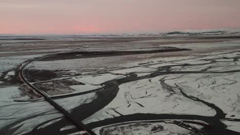 beautiful snowy winter landscape with car on bridge road during sunrise