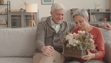 happy senior couple receiving flowers