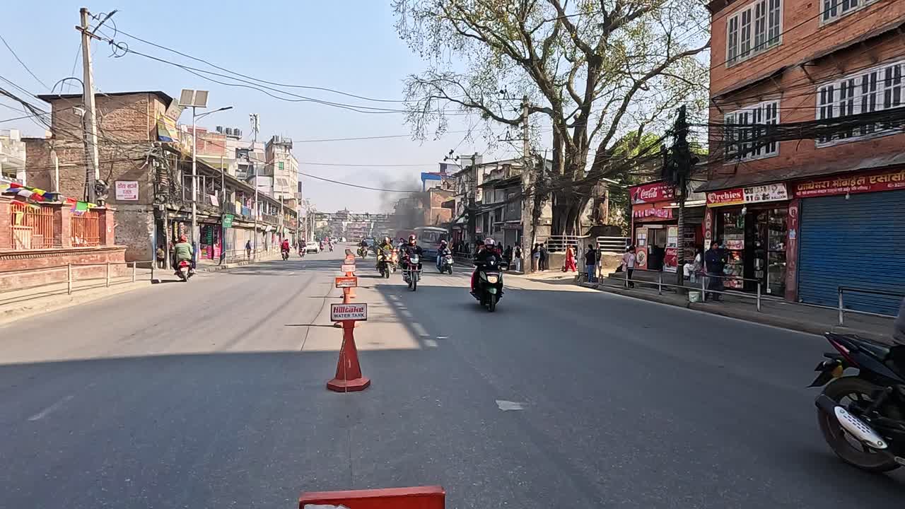 Standing in the middle of a busy road in Kathmandu, Nepal.  chaotic and vibrant traffic flow. Vehicles and motorbikes weave through the bustling urban streets, showcasing the energetic commute