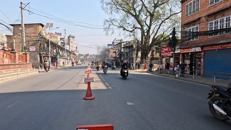 standing in the middle of a busy road in kathmandu, nepal.  chaotic and vibrant traffic flow. vehicles and motorbikes weave through the bustling urban streets, showcasing the energetic commute