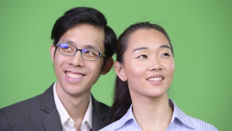 young happy asian business couple thinking together