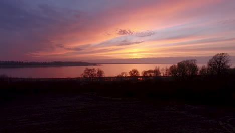 lake burtnieks in late autumn red sky sunset aerial wide view wit tree silhouette