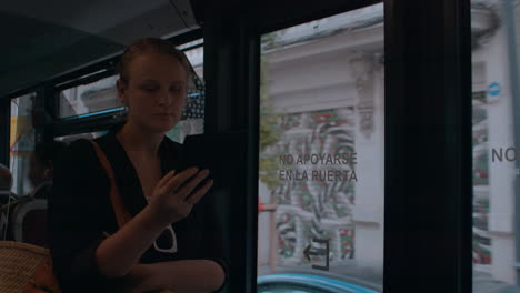una mujer lee un lector electrónico en un autobús.