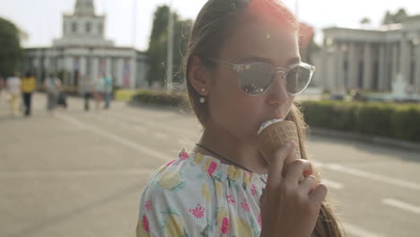 chica adolescente relajada caminando en un parque de atracciones. chica linda comiendo helado