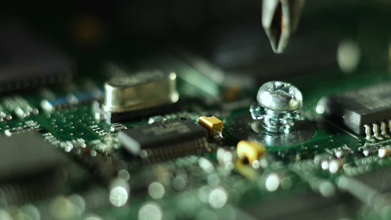 Extreme close-up of tightening a screw on a computer motherboard with copy space.