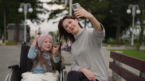 mamma takes selfies while little girl making funny gestures