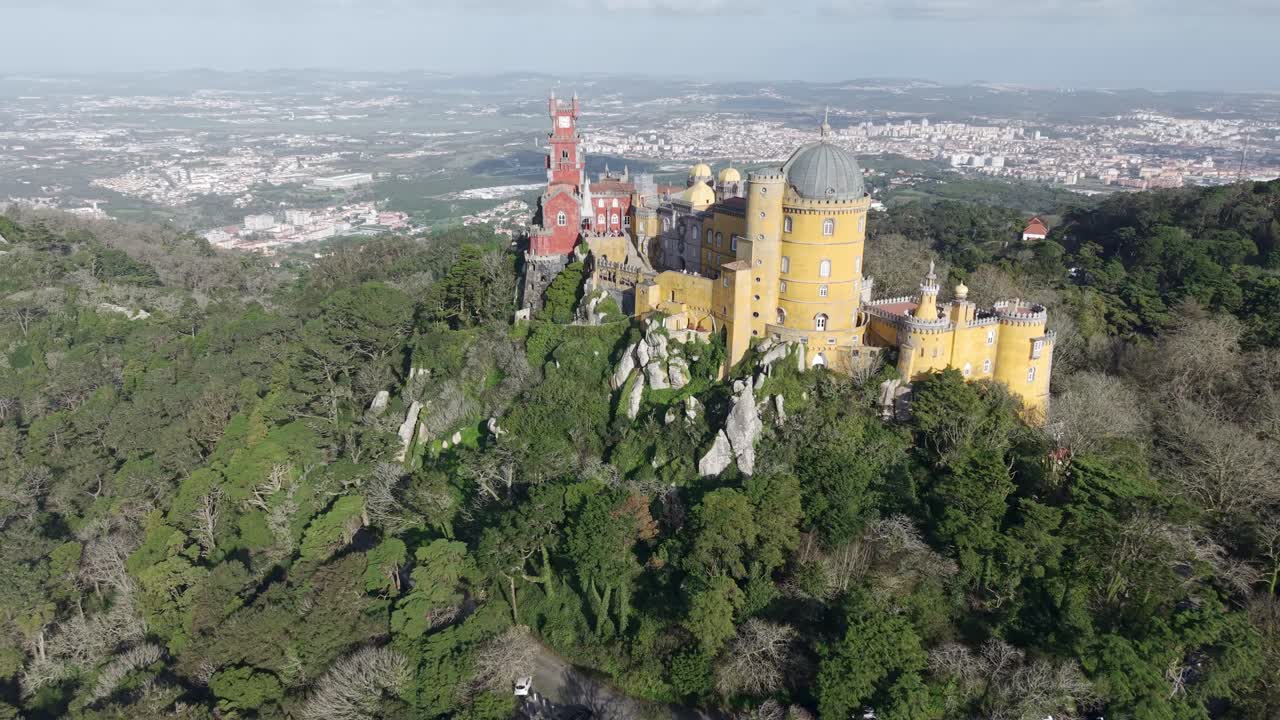 The Pena National Palace in Sintra mountains and forest above the town of Sintra, Drone shot