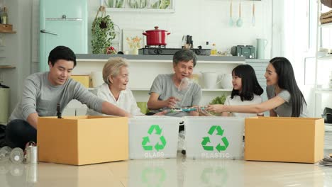 asian family helping to separate plastic bottle into recyclable bin at home together.