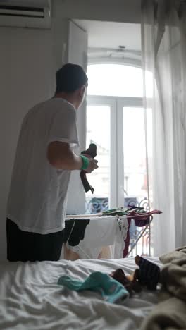 man doing laundry in a bedroom