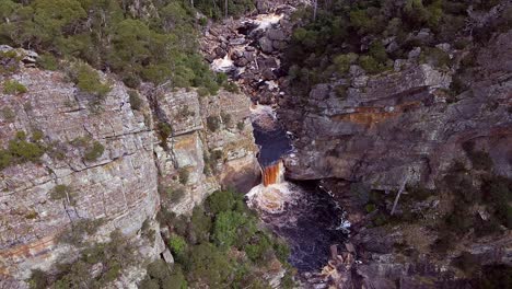 Vista-Aérea-De-Pequeñas-Cascadas-A-Través-De-Los-Acantilados-Del-Cañón-Leven-En-Tasmania,-Australia