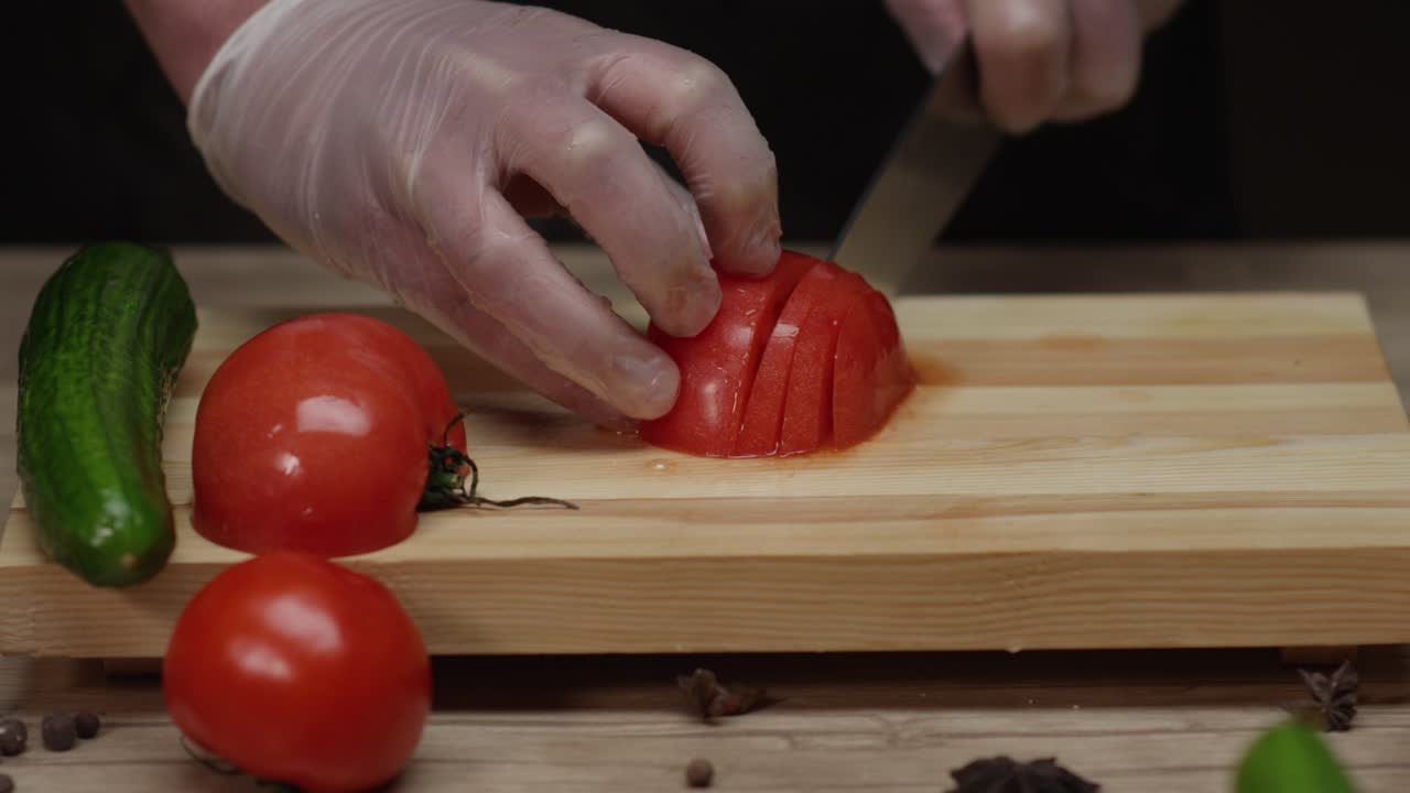 A skilled chef slices a vibrant red tomato, showcasing precision and freshness. Each cut reveals juicy interiors, highlighting the art of culinary preparation.