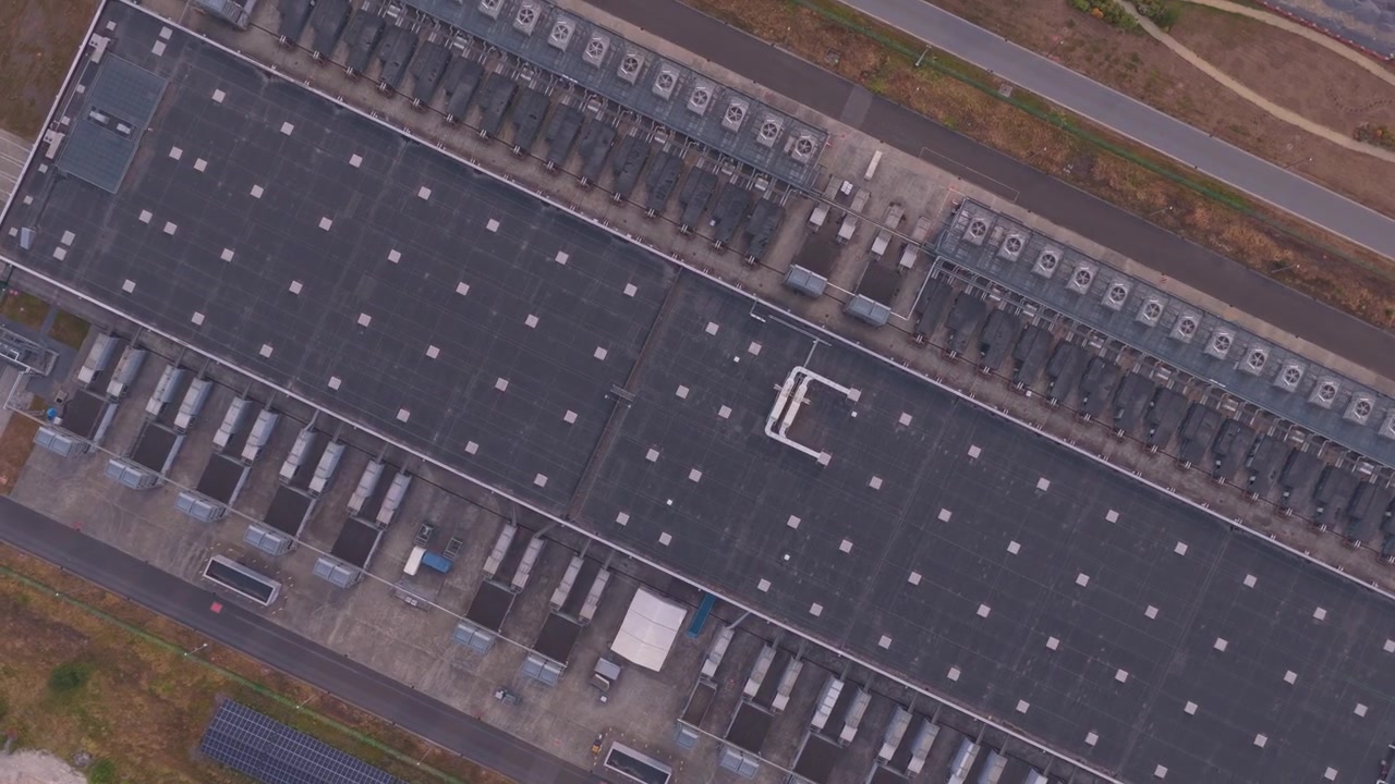 Droneoptagelse ovenfra af et stort datacenteranlæg med adskillige køleenheder på taget, afgørende for AI- og cloud computing-infrastruktur