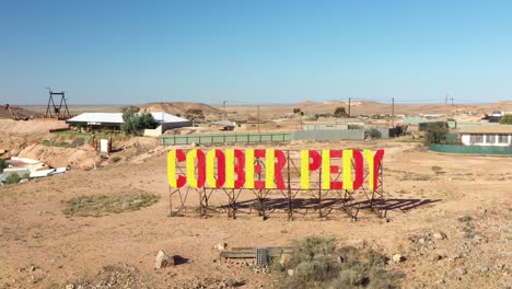 Excelente-Toma-Aérea-Del-Letrero-Que-Da-La-Bienvenida-A-La-Gente-A-Coober-Pedy,-Sur-De-Australia