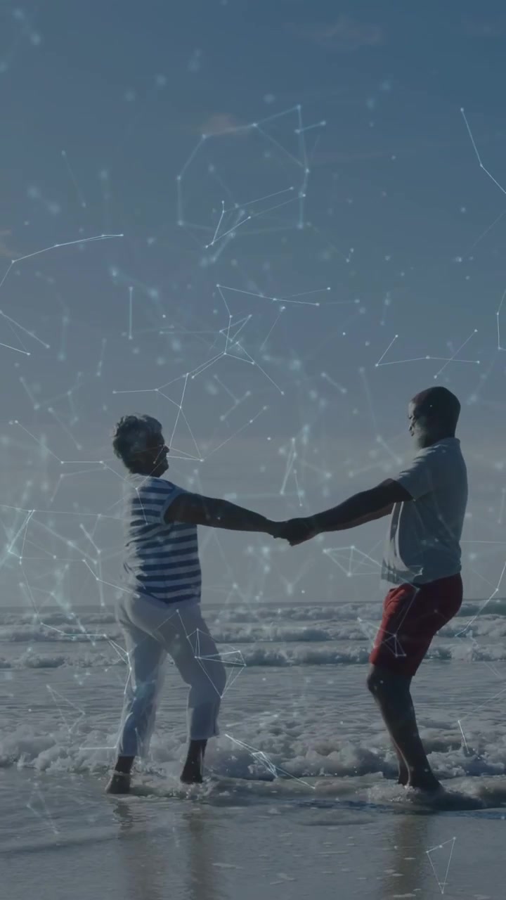 Vertical video: Couple holding hands at surf, rotating for travel shoot, star overlay framing them