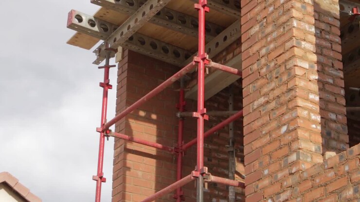 Inquadratura inclinata di un cantiere di costruzione di una nuova casa che mostra impalcature al secondo piano