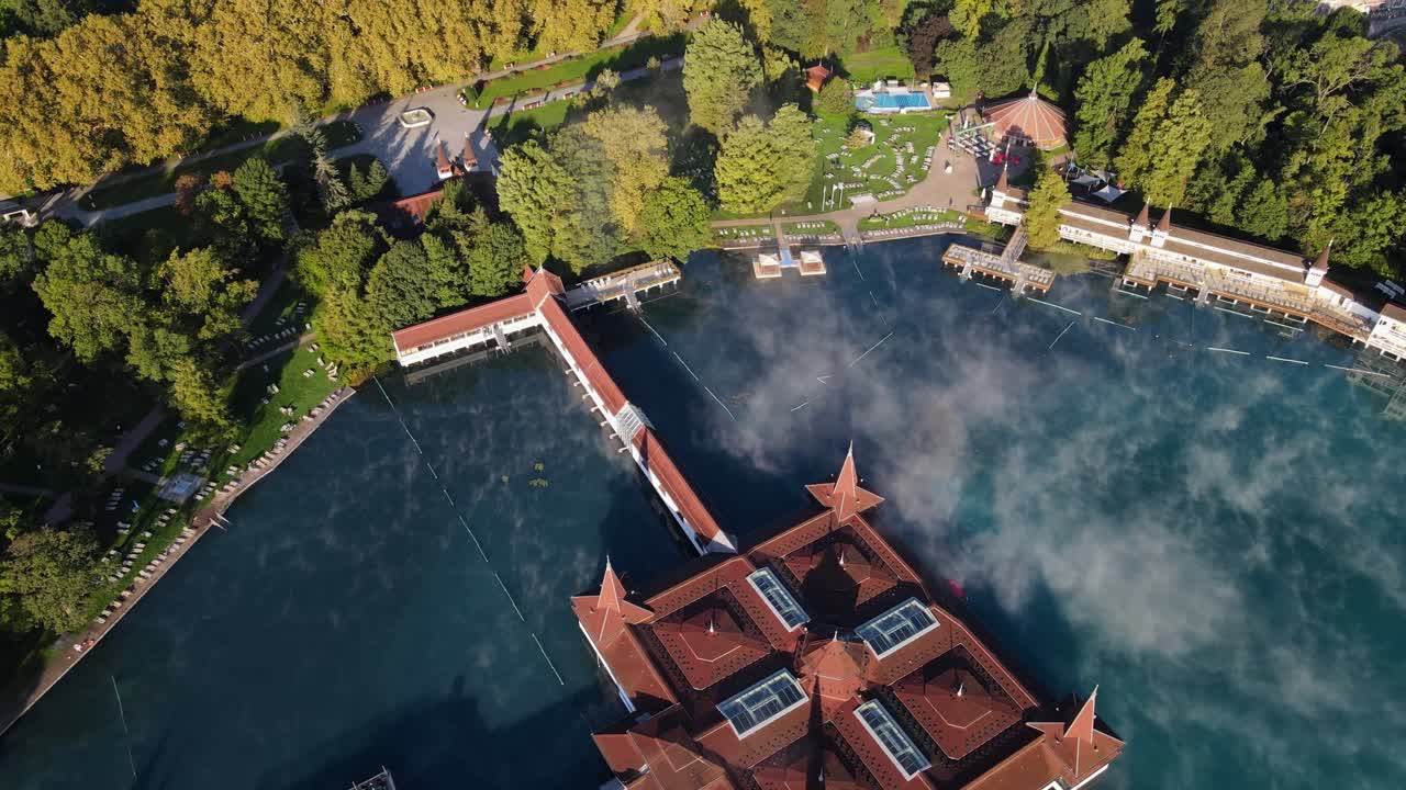 Aerial view of thermal spa in nature setting, flying through with a drone