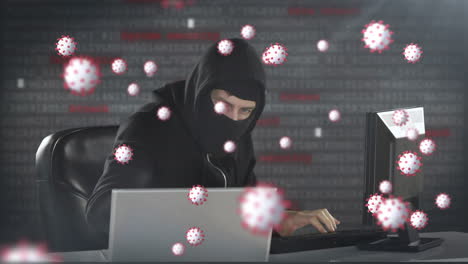 animation of of macro covid19 cells over man wearing balaclava, using a laptop