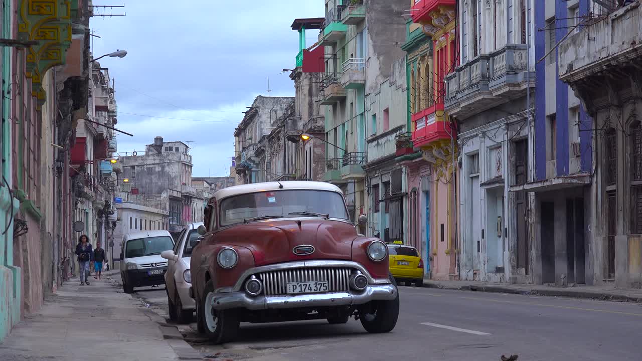 gran toma de calles y callejones concurridos de la ciudad vieja de la habana cuba con un primer plano clásico de autos viejos