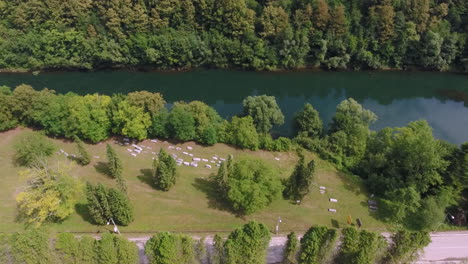 a drone flight over a scenic view of an ancient graveyard and a river and main road that follows its course