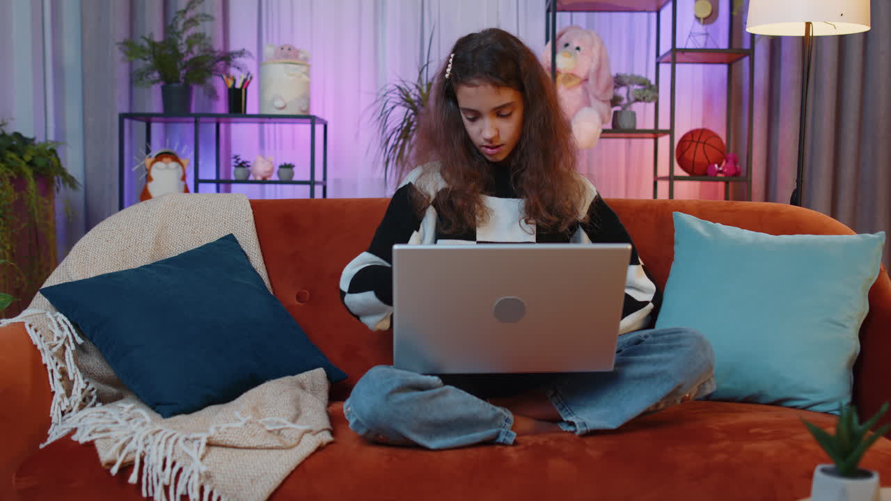 una joven freelancer comienza a trabajar en una computadora portátil, envía mensajes, hace compras en línea en casa