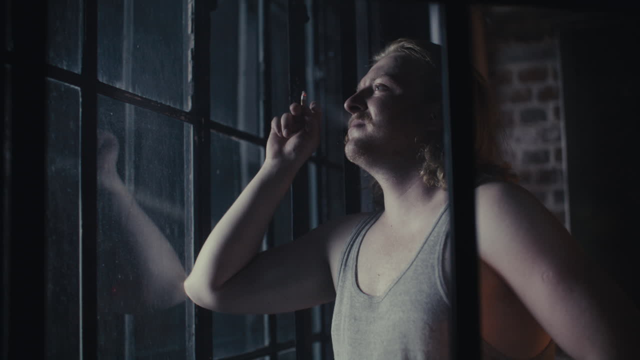 Man Smoking by a Window at Night