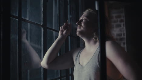 man smoking by a window at night