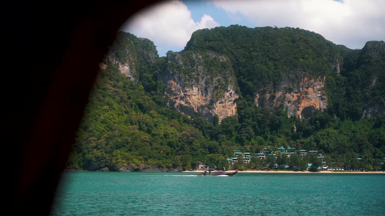 Beautiful view of a traditional Thai boat sailing across the clear blue waters off the coast of Thailand