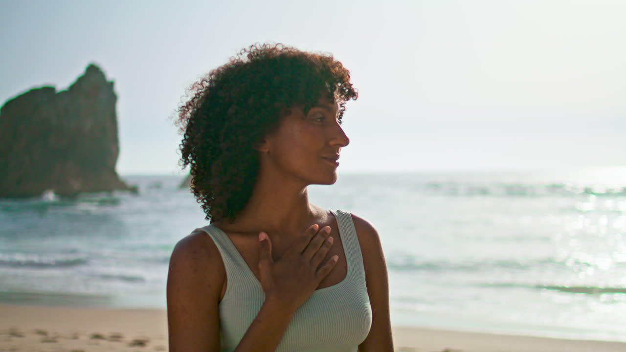 Girl enjoy sunrise meditating on beach closeup. Serene woman standing seashore