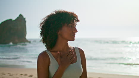 girl enjoy sunrise meditating on beach closeup. serene woman standing seashore