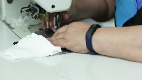 Seamstress-Hand-Carefully-Sewing-A-White-Cloth-Filter-For-Face-Masks---Covid-19-Pandemic---Pan-Right-Shot