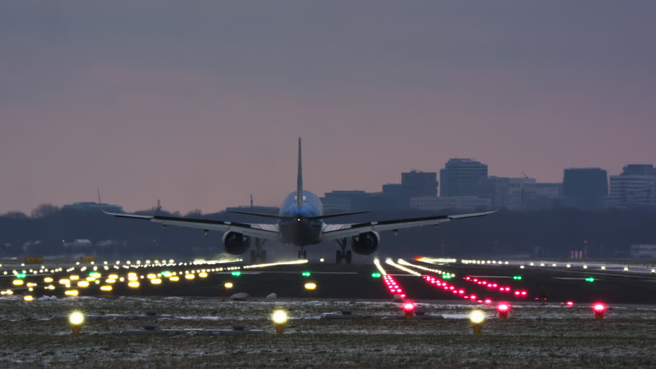 Aereo di linea commerciale in atterraggio su una pista illuminata al crepuscolo.