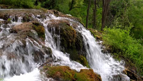 Water-flowing-over-a-rocky-formation-covered-in-moss-at-Krka-National-Park-in-Croatia