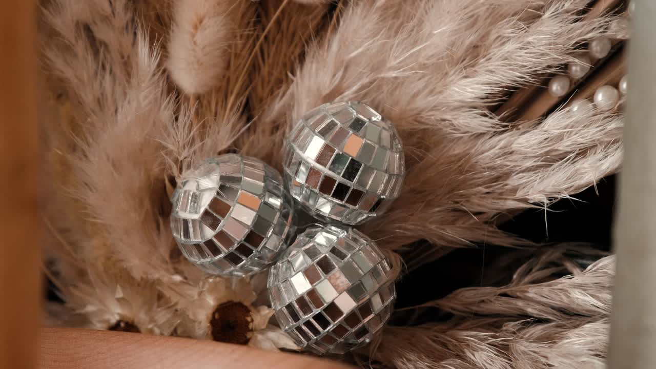 A wedding decor piece with dried flowers and glitter balls