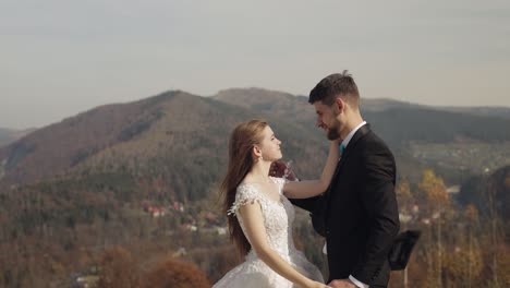 newlyweds. caucasian groom with bride on mountain slope. wedding couple. happy