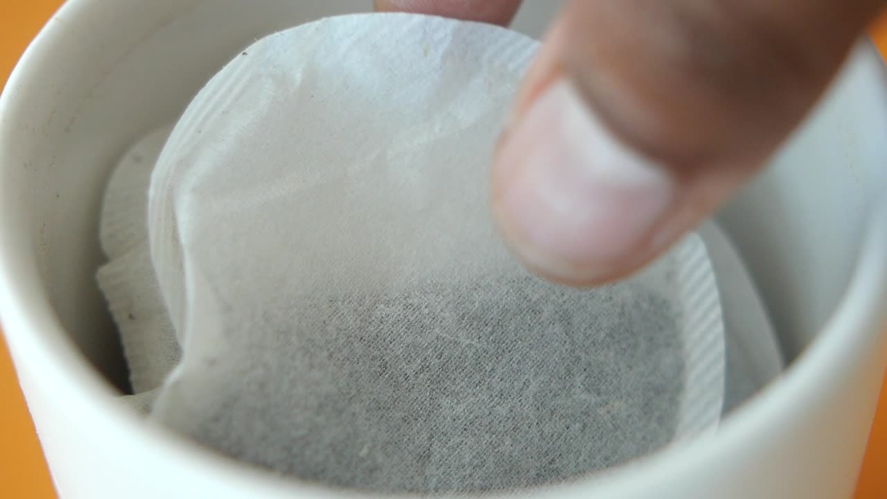primer plano de bolsas de té en una taza blanca