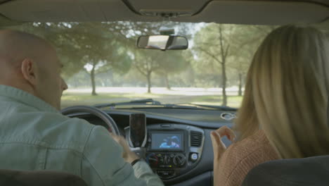 vista trasera de una pareja bailando en el coche