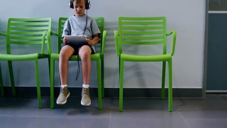 niño usando una tableta digital en el pasillo del hospital