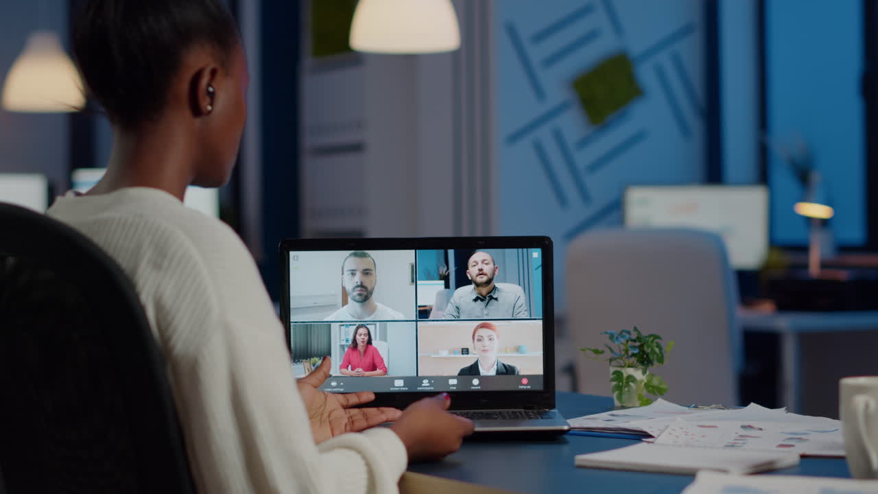 Back view of black business woman talking on video call with team